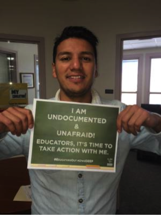 Undocumented UNM Graduate Student, Jaén Ugalde holding an “I am undocumented and unafraid” sign. Photo by John Acosta/NM News Port