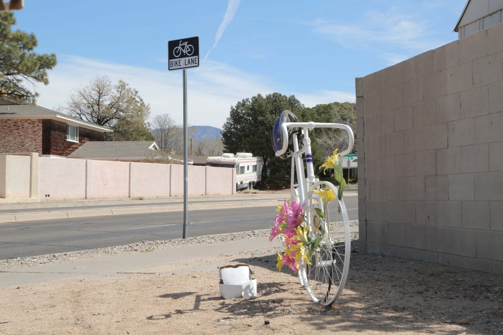 Paula Higgins, who passed away in 2006 while riding her bike on Comanche Road near Pennsylvania Street, has a ghost bike set up in her remembrance. Comanche Road includes one of the longest bike lanes in Albuquerque, N.M. Photo by Jaclyn Younger / NMNP