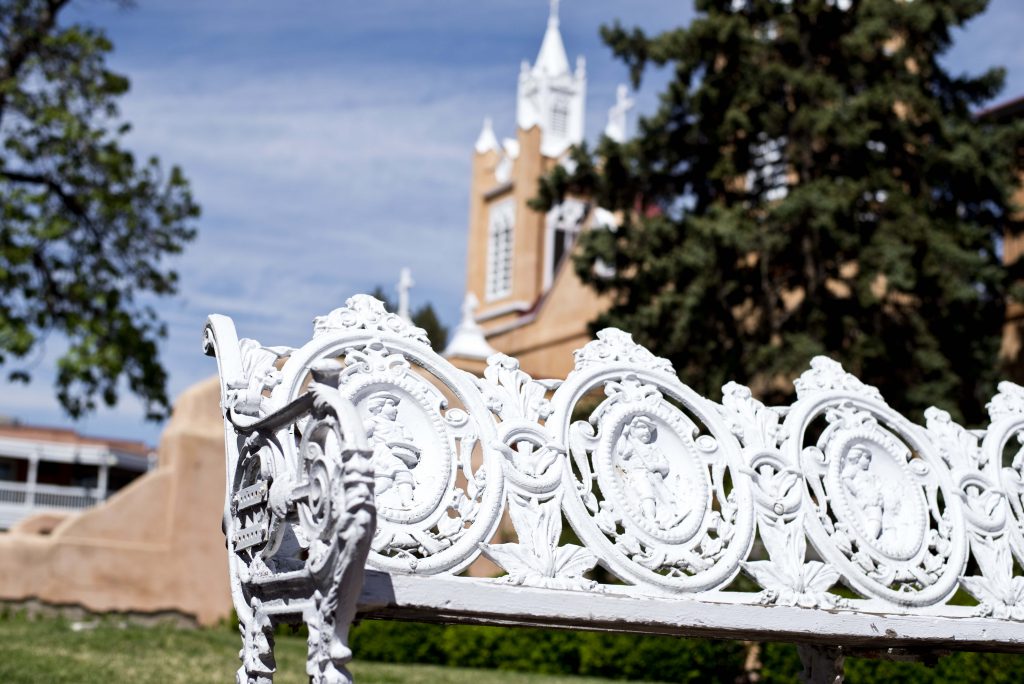 San Felipe De Neri Parish stands behind old trees and benches that adorn the walkway to the doors of the church. Thursday, April 17, 2015. Photo by Nick Fojud/NMNP