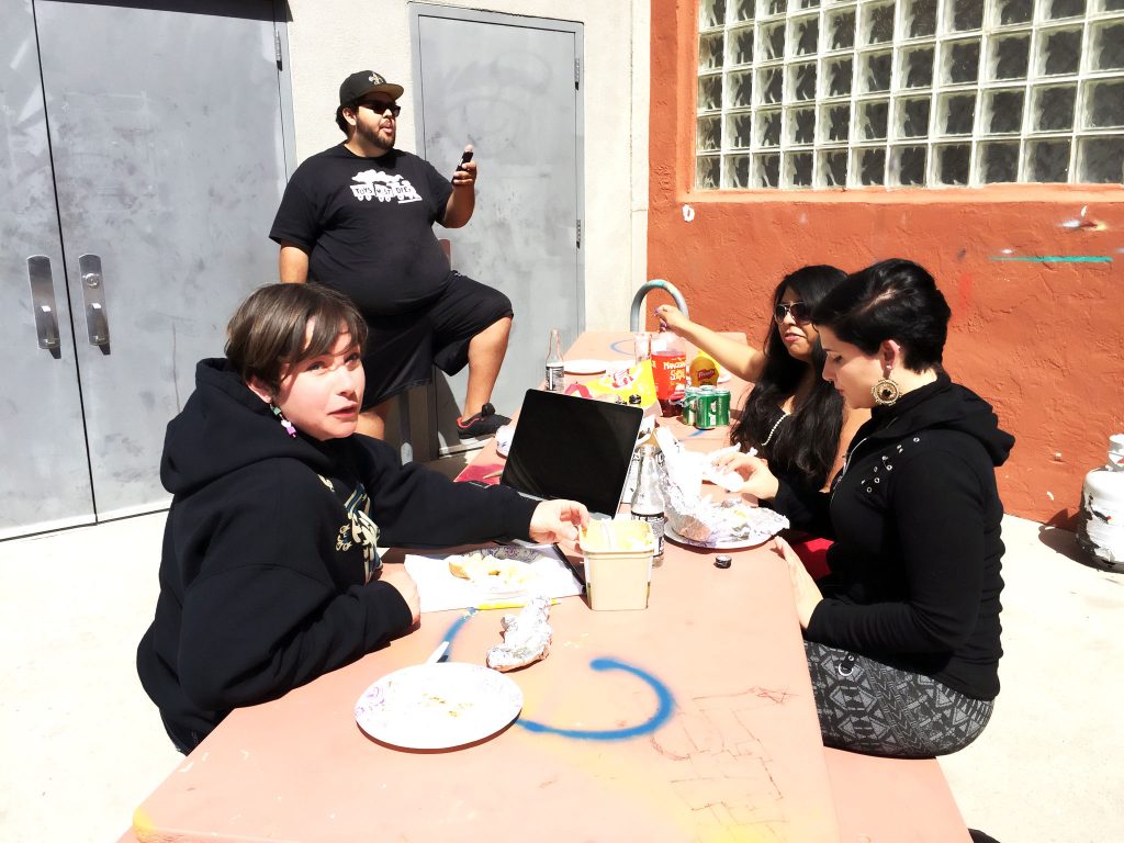 Warehouse 508 staff (from left to right) April Freeman, “Berto” Roberto Reyes, Ruby Rodriguez and UNM intern Keara Dayton share BBQ pork ribs and potatoes on the patio on a recent day. Photo by Mercedez Holtry/ NM News Port