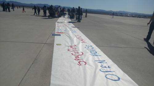 Children decorate a banner commemorating the Spaceport’s second biannual open house. Photo by Marissa Higdon / NM News Port.