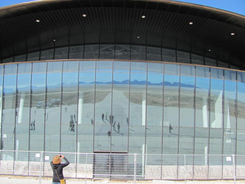 The image of surrounding mountains is reflected in the windows of the spaceport. Photo by Marissa Higdon / NM News Port