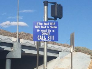 Citizens in need of basic assistance like food or shelter are encouraged to call 311 as part of an initiative to provide panhandlers with jobs.The program’s signs are found on Albuquerque’s busiest intersections. Photo by Allison Romero / NM News Port